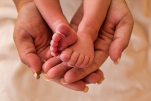 Tiny infant feet held in the mother's hands